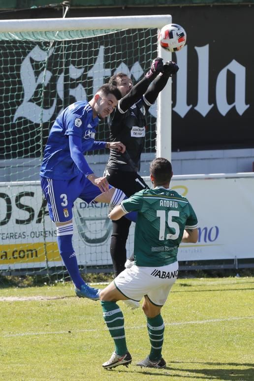 Alberto, portero del Coruxo, despeja el balón ante Armenteros. // R. GROBAS