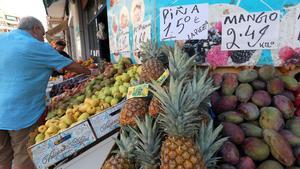 Un hombre compra en una frutería de València.