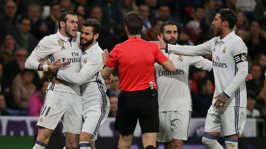 Nacho sujeta a bale mientras Fernández Borbalán se echa la mano al bolsillo para sacar la tarjeta roja.