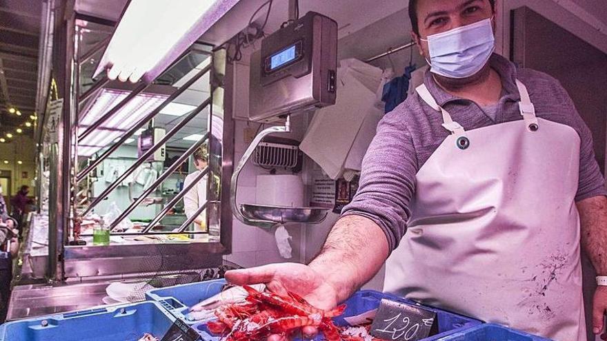 Vendedores de marisco que ofrecen gamba roja y cigalas en el Mercado Central de Alicante.