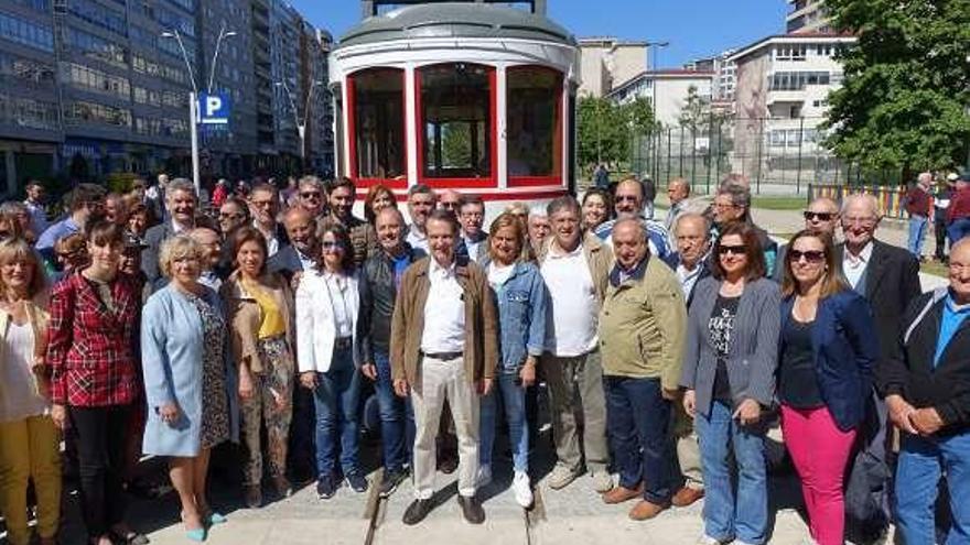 Caballero, con miembros de su lista, simpatizantes y vecinos, ayer, frente a la réplica de un antiguo tranvía instalado en Castelao. // FdV