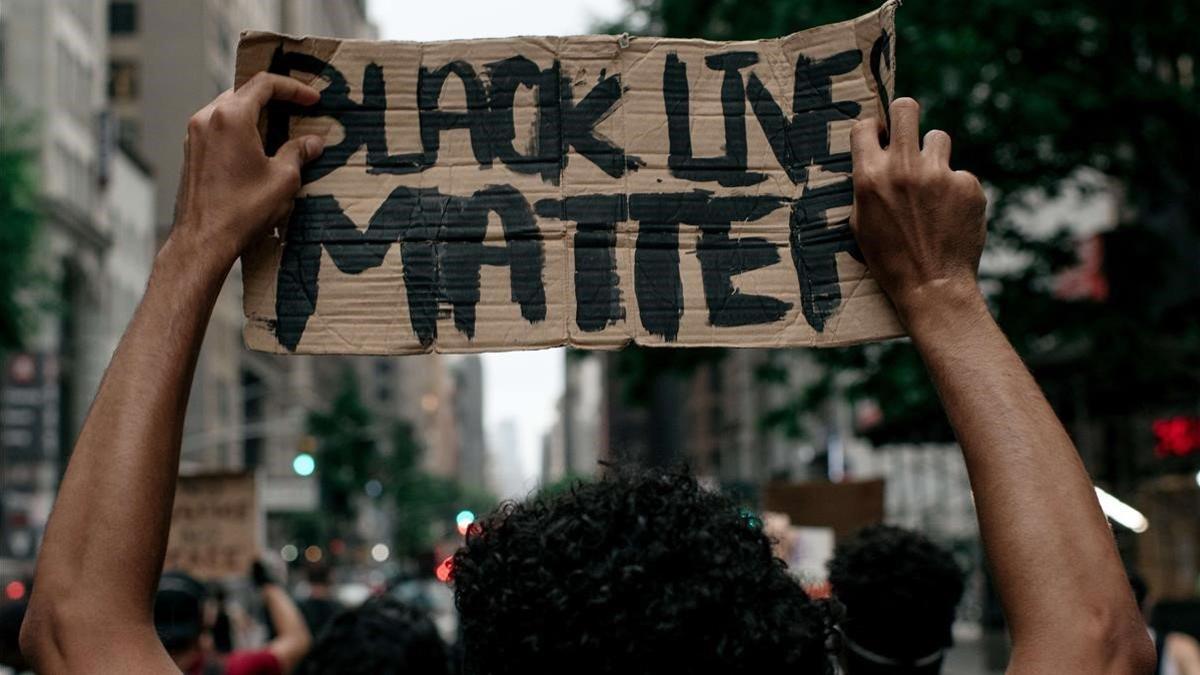 Un manifestante porta un cartel con el lema 'Black Lives Matter' (las vidas negras importan) en una manifestación en Nueva York, el 11 de junio.