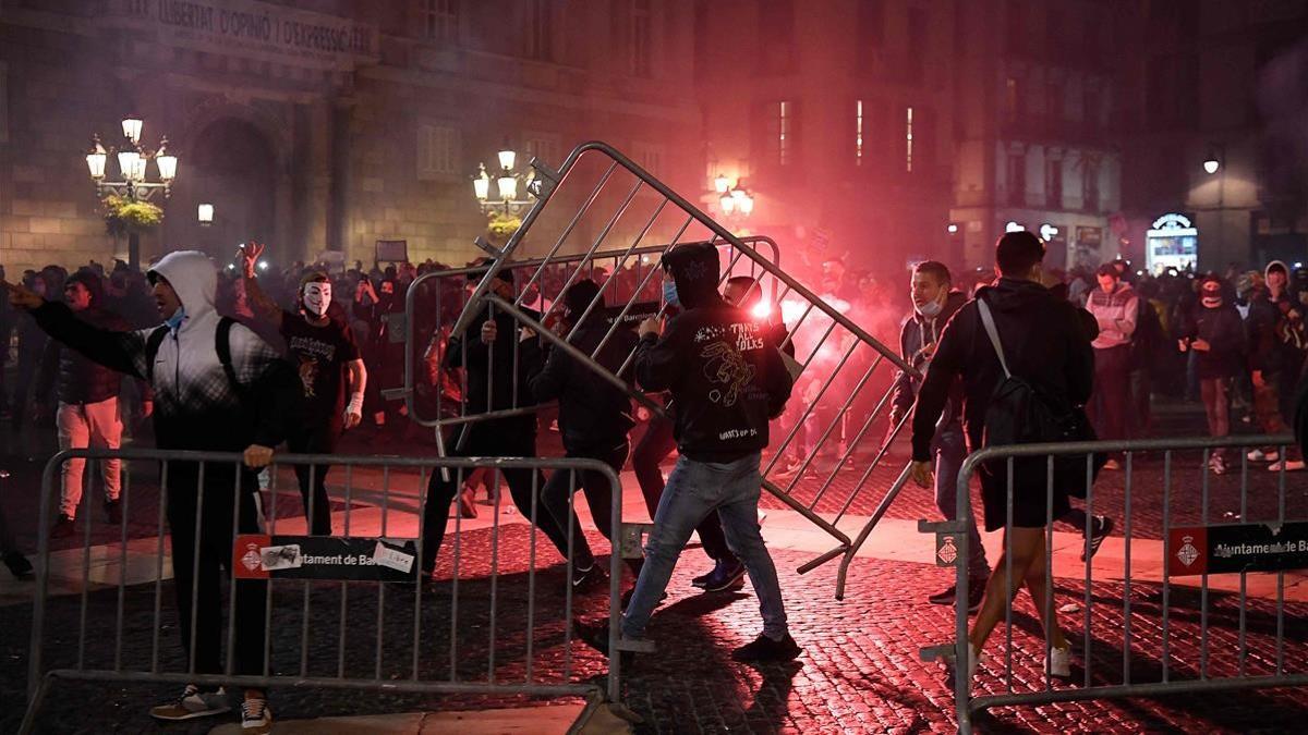 Protesters remove crowd control barriers during clashes members of the Catalan regional police force Mossos d Esquadra at a demonstration against new coronavirus restrictions in Barcelona on October 30  2020  - One by one  Spain s regions have announced regional border closures in the hope of avoiding a new lockdown like in France  The central government unveiled a state of emergency to give regional authorities the tools to impose curfews and close their borders to anyone moving without just cause  (Photo by Josep LAGO   AFP)