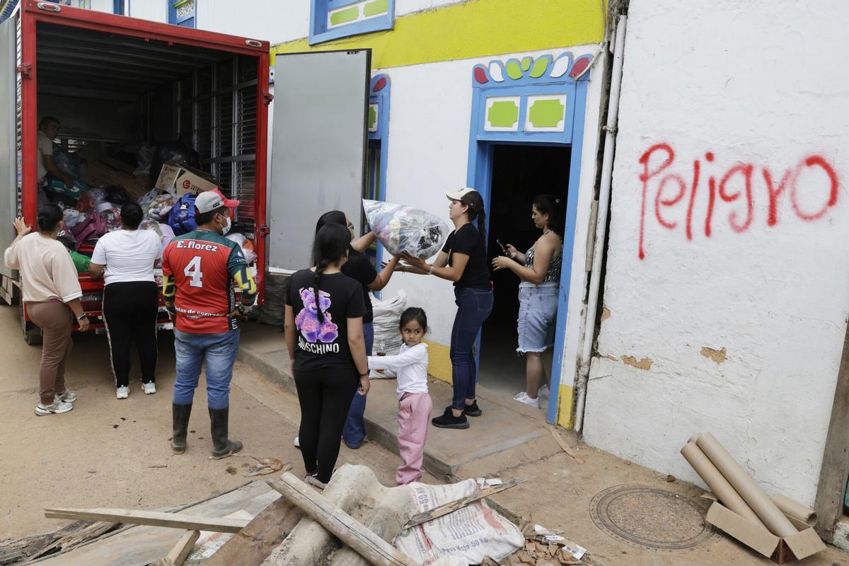 Un grupo de personas descargan un camión con ayuda humanitaria en El Cairo (Colombia).