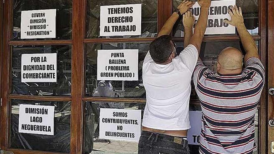 Empresarios del sector pegan carteles de protesta ayer.