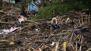 Una mujer permanece sentada en medio de los destrozos causados por el ciclón ’Mocha’ en el campo de refugiados de Sittwe, en Birmania.