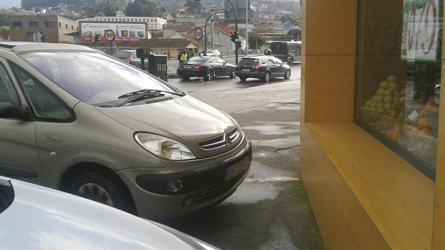 El vehículo de los detenidos, a la izquierda, rodeado de policías.