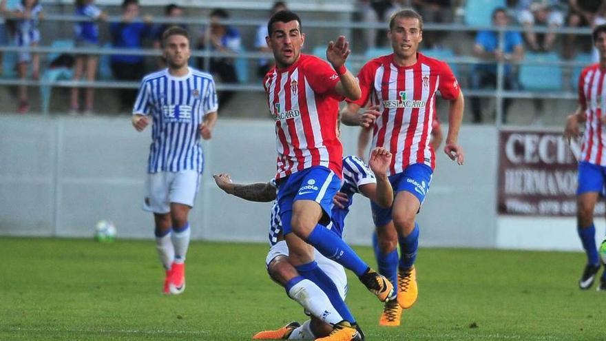 Carlos Castro disputa el balón con un jugador de la Real Sociedad, con Álex Bergantiños detrás.