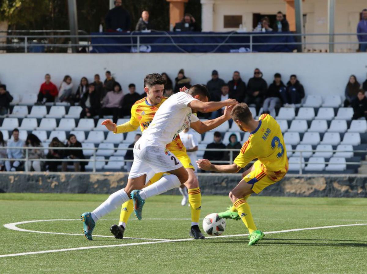 Jesús Fortes contra dos jugadores del Lleida Esportiu. | VICENT MARÍ