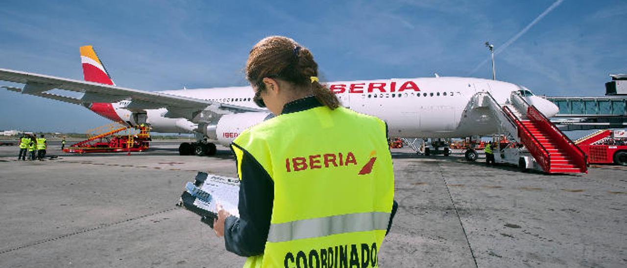 Una trabajadora de Iberia frente a una de las aeronaves de la compañía.