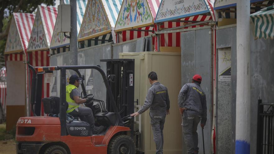 Operarios desmontan una caseta en las instalaciones de la Feria de Abril de Sevilla