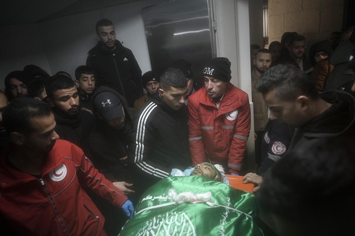 Un grupo de hombres velan el cadáver de Mohamed Jalamneh en la morgue del hospital Ibn Sina de Yenín, este martes.