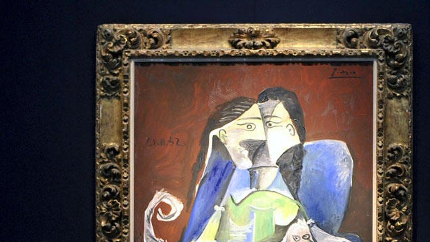 Una empleada de la casa de subastas Christie&#039;s observa la pintura &quot;Femme au chien&quot; (1962), del pintor español Pablo Picasso, expuesto en la sede de Christie&#039;s en Londres.