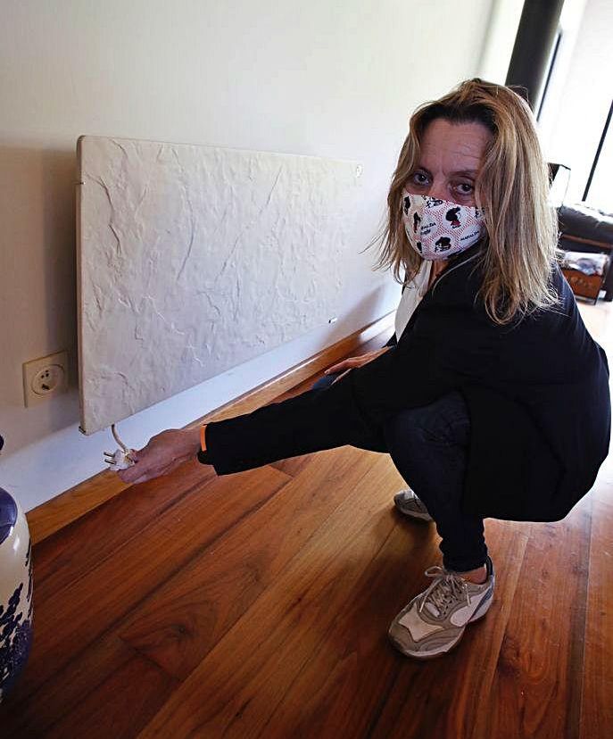 Isabel Vinagre desenchufando un radiador eléctrico en su vivienda. | Ángel González