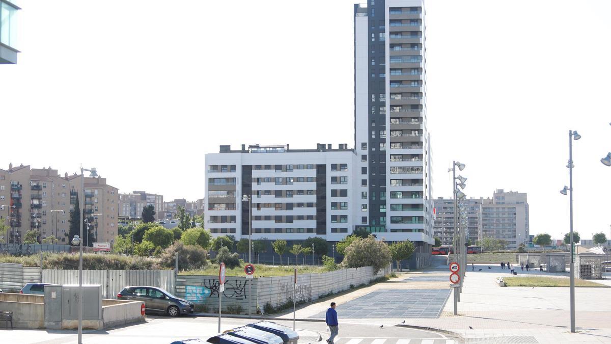 En la parte delantera de la imagen, vallado, el solar que quiere vender ZAV este año; al fondo, la manzana colindante, ya construida y habitada.