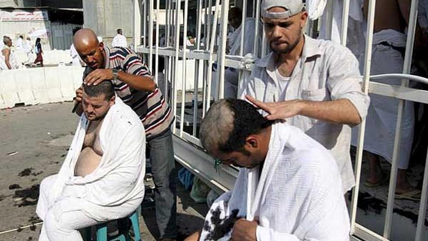 Dos barberos afeitan a peregrinos después de lanzar piedras sobre los tres pilares, en La Meca.