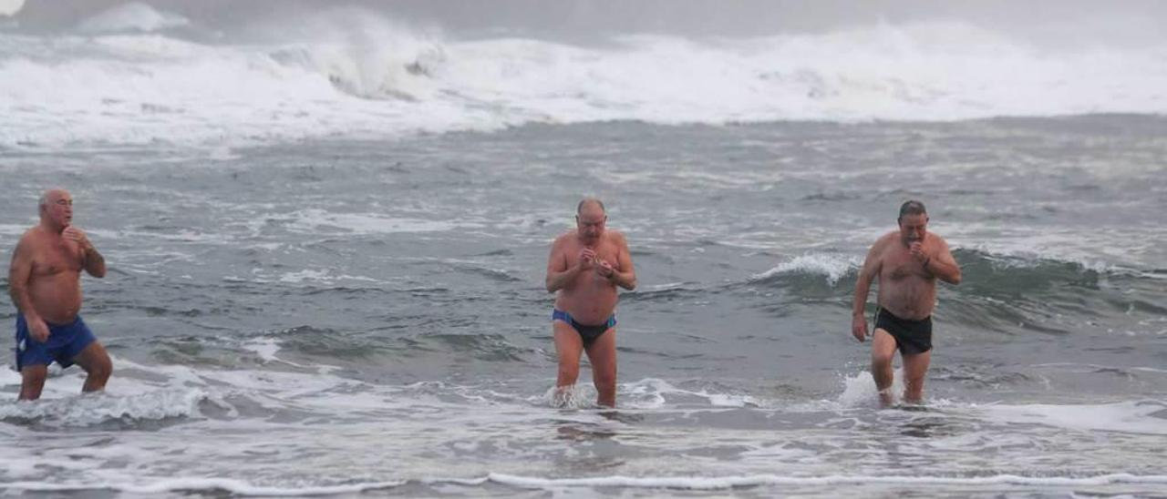 Por la izquierda, César Coto, Jaime Jardón e Isidoro Treceño salen del agua tras haberse dado un baño en la playa de Salinas el pasado miércoles.