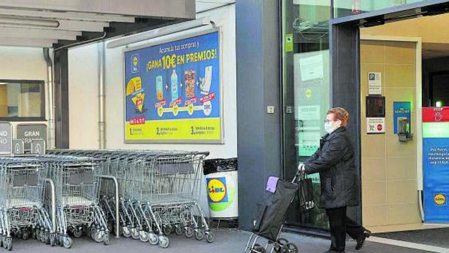 Una mujer sale con la compra de un supermercado. |   // ALBA VILLAR