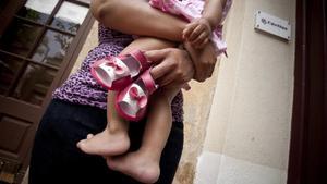 Una madre, junto a su hija, en el centro maternoinfantil de Cáritas en Badalona. 