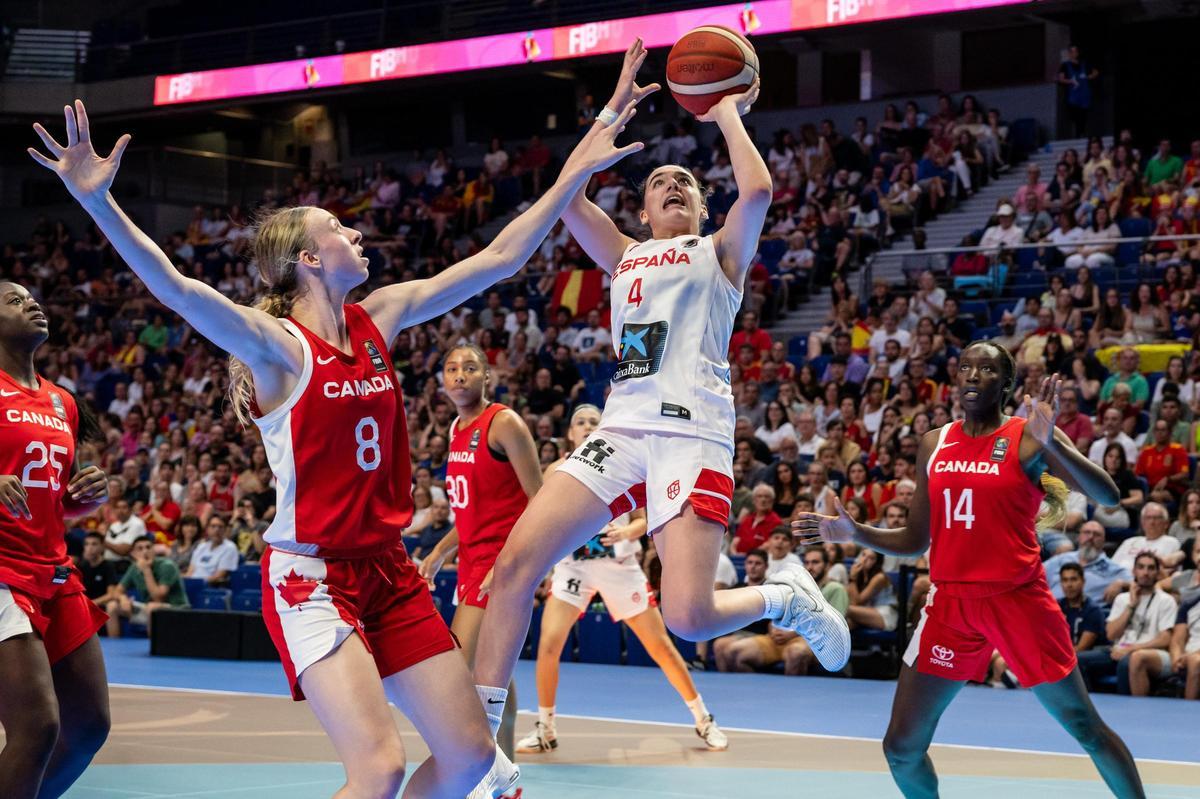 La base de la selección española Iyana Martín (c) se dispone a lanzar ante Toby Fournier (i), de Canadá, durante la semifinal del Mundial de baloncesto femenino sub-19 disputada este sábado en el Wizink Center, en Madrid. EFE/Fernando Villar