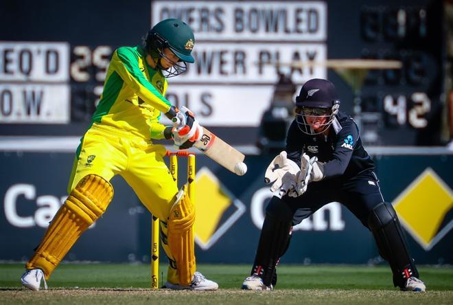 La jugadora australiana Rachael Haynes juega un tiro mientras la wicketkeeper de Nueva Zelanda Katey Martin (R) mira durante el segundo partido de cricket internacional de un día (ODI) entre Australia y Nueva Zelanda en Alan Border Field.