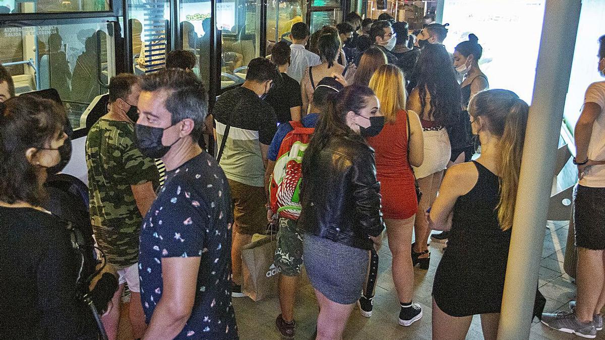 Un grupo de usuarios se dispone a subir al autobús nocturno en la parada de Plaza del Mar.