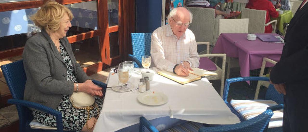 Michael Daniel Higgins firma en el libro de honor del restaurante Puerto Bahía.