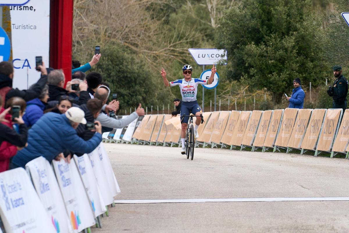 Remco Evenepoel levant los brazos al entrar en la meta de Lluc