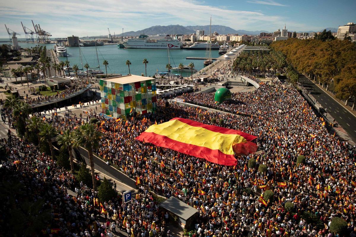 Los manifestantes marchan con una bandera gigante en Málaga durante una protesta convocada por la oposición de derecha contra un proyecto de ley de amnistía para las personas involucradas en el fallido intento de independencia de Catalunya de 2017, el 12 de noviembre de 2023.