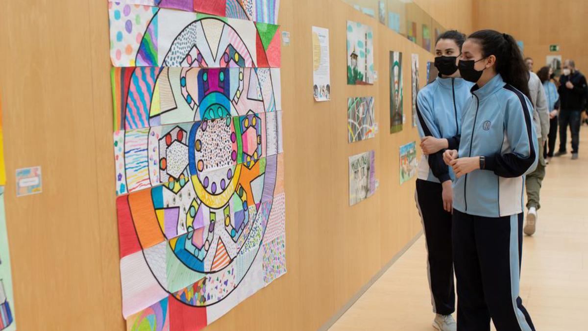 Dos estudiantes observan un colorido rosetón en la exposición. | Emilio Fraile
