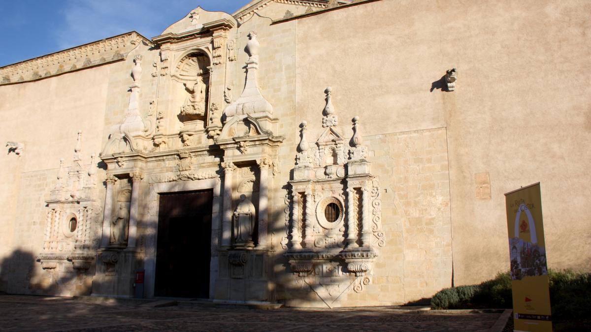 Exterior de l&#039;església del Monestir de Poblet, amb un cartell de La Ruta del Cister a la dreta