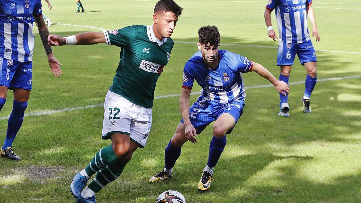 Martín Rafael, del Coruxo, controla el balón ante la presencia del asturiano Nacho López, durante el partido de ayer en Pardellas. |  // P. HERNÁNDEZ