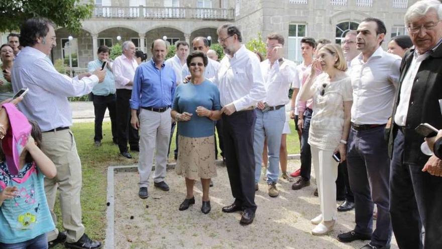 Rajoy, en el centro, fotografiado con una vecina que ayer se acercó al balneario de Mondariz.