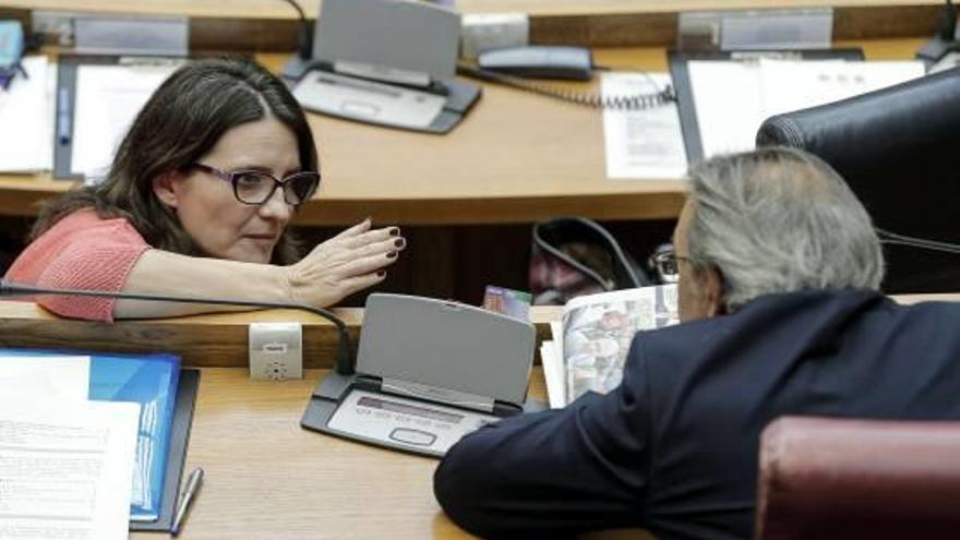 La vicepresidenta Mónica Oltra conversa con Manolo Mata en un pleno de las Cortes.