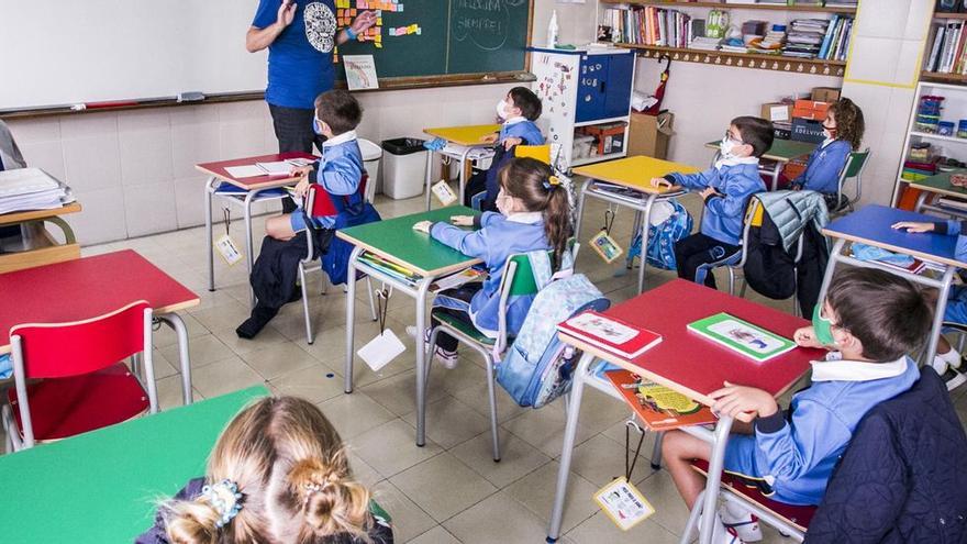 Un maestro explica en un aula de un colegio.