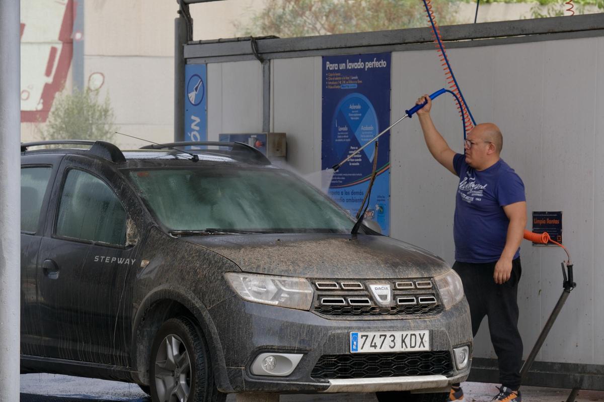 Un conductor limpia el barro de su coche en un lavauto de Palma