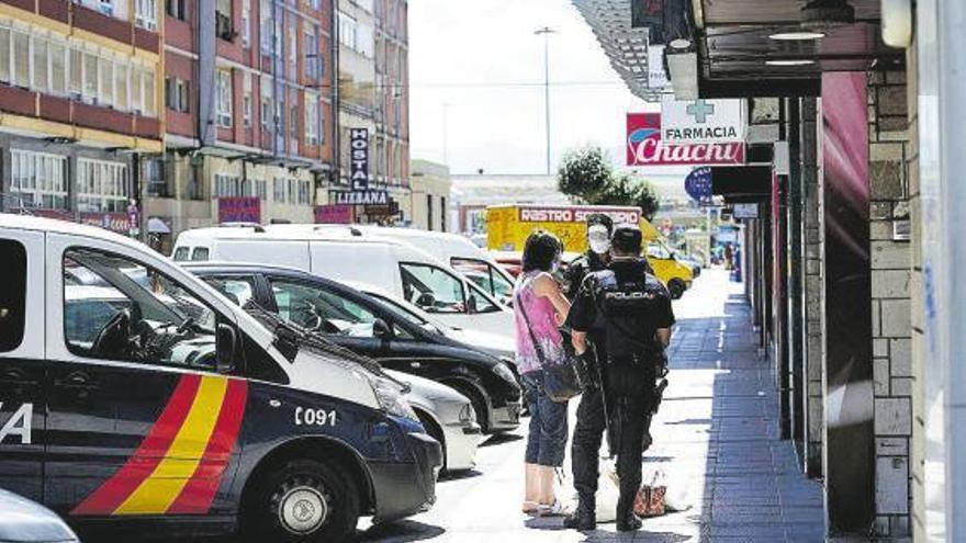 Dos policías explican a una vecina que no puede salir del edificio en cuarentena en Santander.