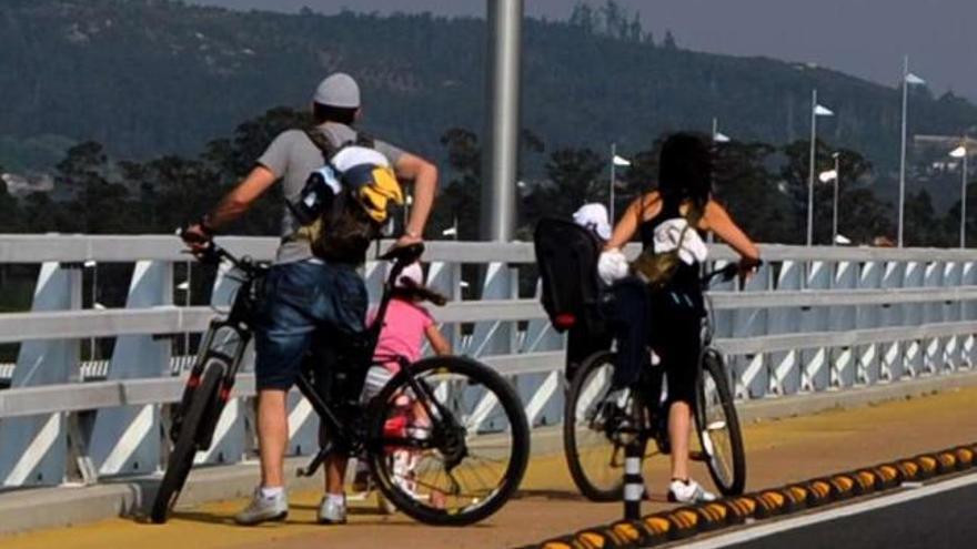 Unos padres pasean en bicicleta con sus dos hijos pequeños. / iñaki abella