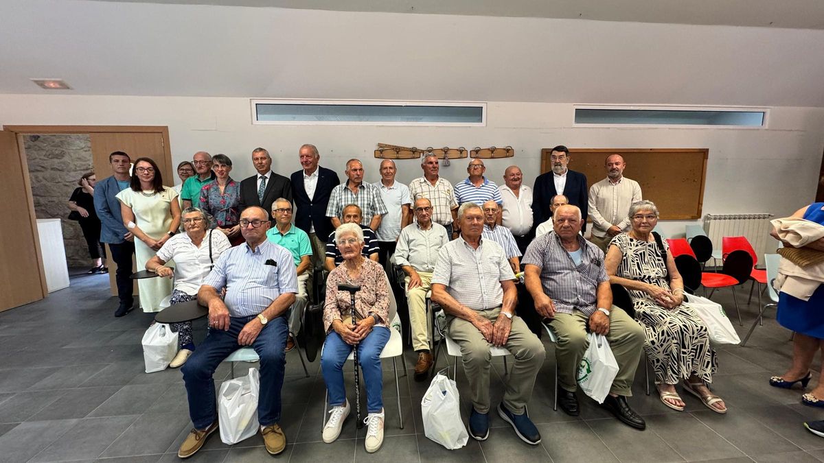 Xubilados e xubiladas homenaxeados en Muros; detrás, as autoridades que asistiron ao acto.