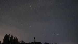 Los expertos recomiendan alejarse de núcleos urbanos para contemplar las Perseidas. En la foto, Perseidas cruzan el cielo sobre la localidad cántabra de Comillas, la madrugada del viernes.