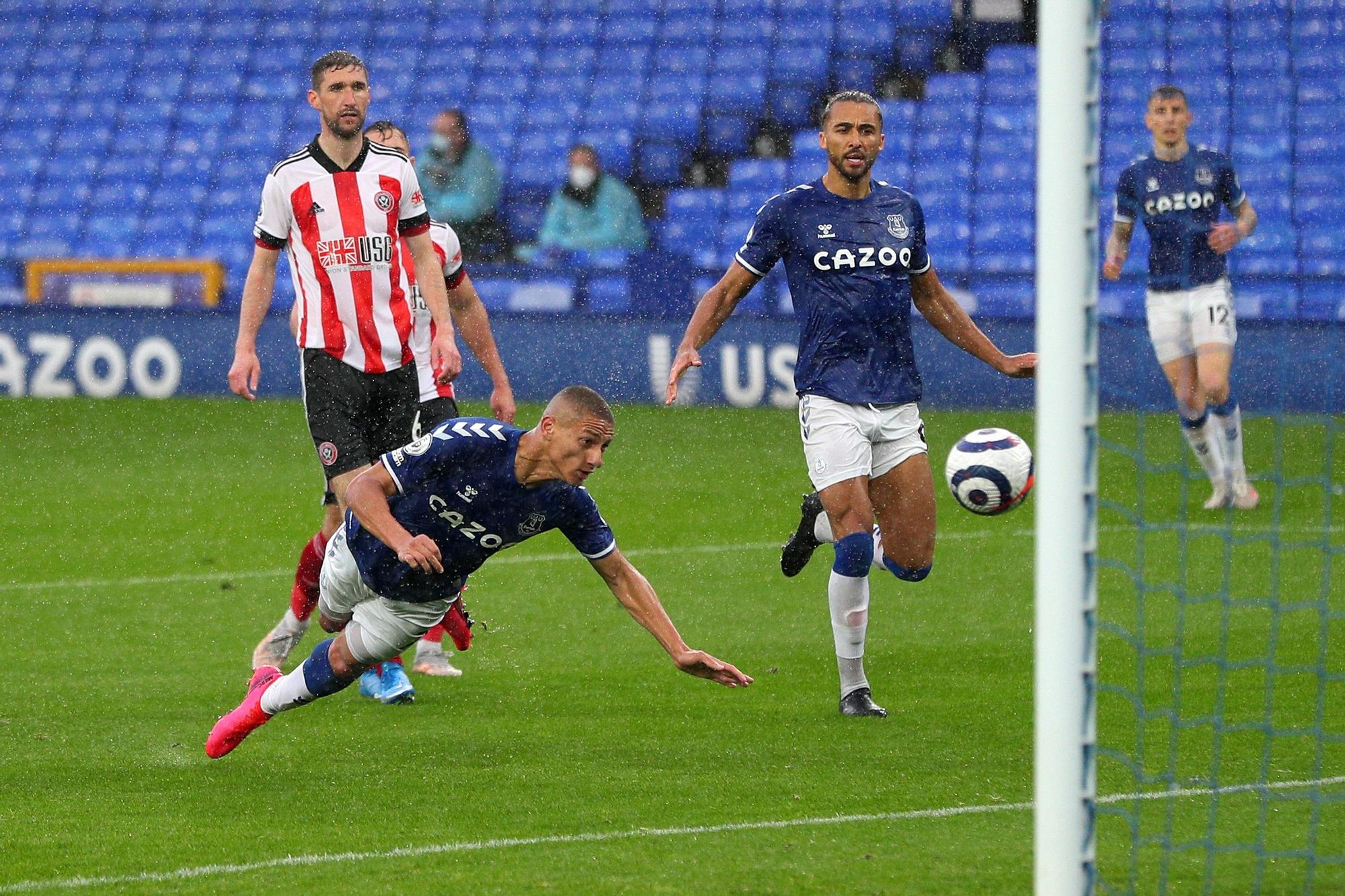 Richarlison rematando de cabeza bajo la lluvia