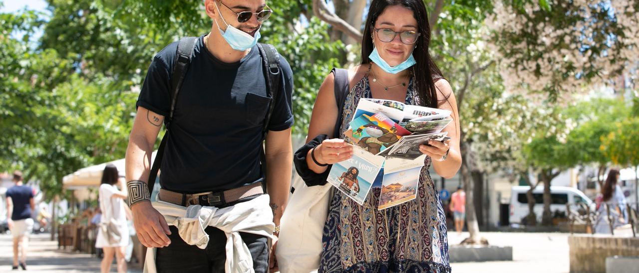 Dos jóvenes en la calle con la mascarilla medio puesta. Vicent Marí