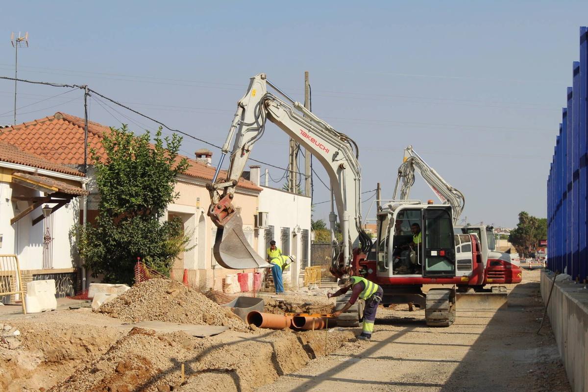 Operarios trabajan en la instalación de las nuevas tuberías de abastecimiento junto a las viviendas de la carretera de Sevilla.