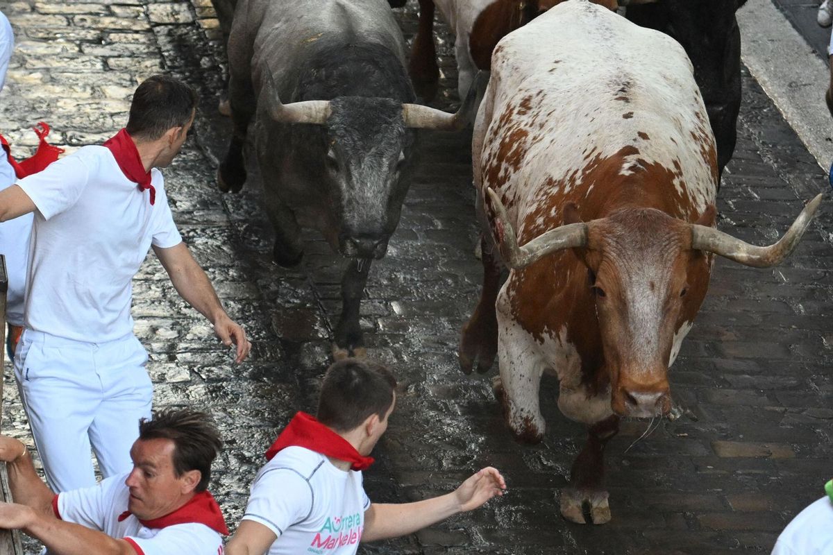 PAMPLONA, 12/07/2025.- Los mozos son perseguidos por los toros de la ganadería de José Escolar en el sexto encierro de los Sanfermines, este sábado en Pamplona. EFE/José Luis Larrión