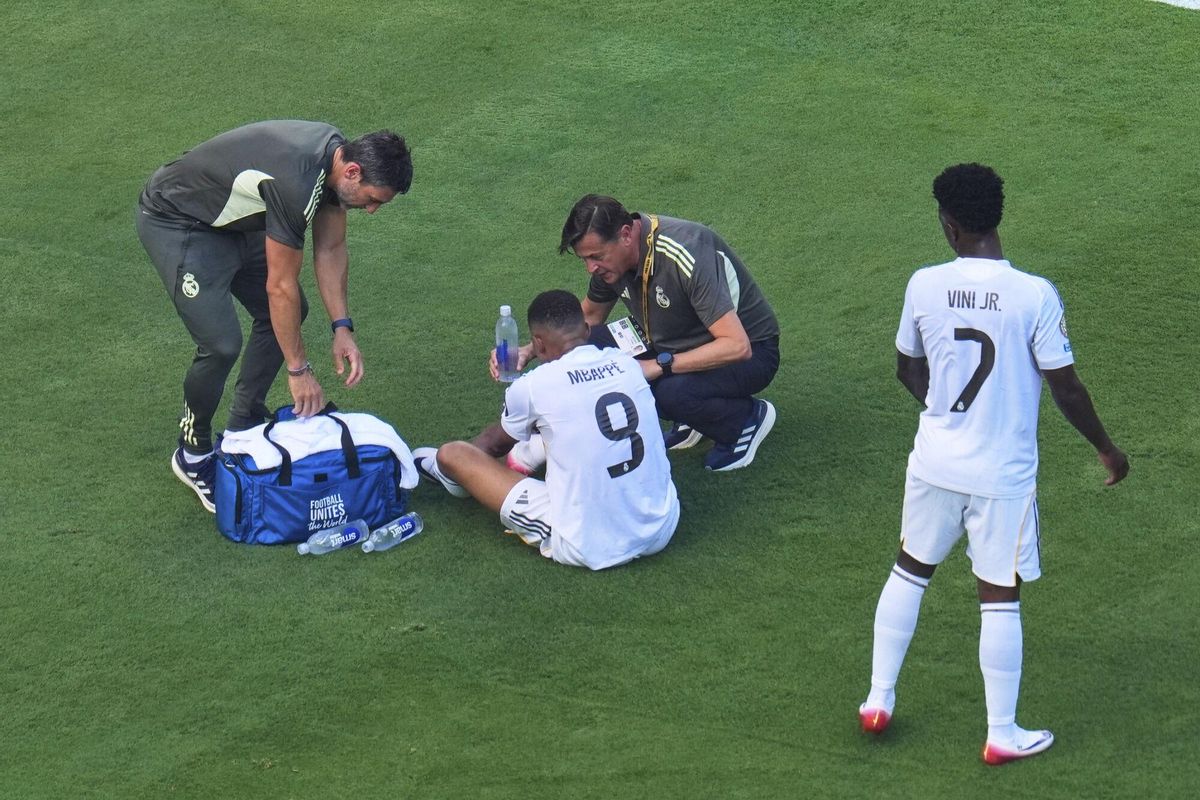 Real Madrids Kylian Mbappe (9) is checked out by team staff after a play against Paris Saint-Germains Joao Neves (87) as Vinicius Junior (7) looks on during the Club World Cup semifinal soccer match between PSG and Real Madrid in East Rutherford, N.J., Wednesday, July 9, 2025. (AP Photo/Pamela Smith)