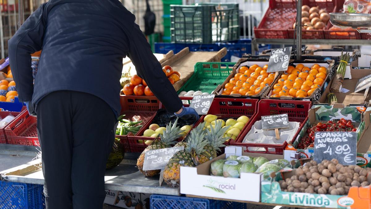 Una persona cogiendo fruta en un mercado de alimentos en Madrid (España)