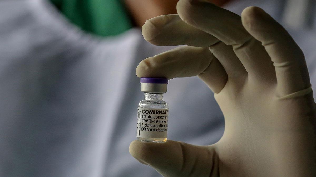 Un sanitario sostiene una dosis de la vacuna de Pfizer