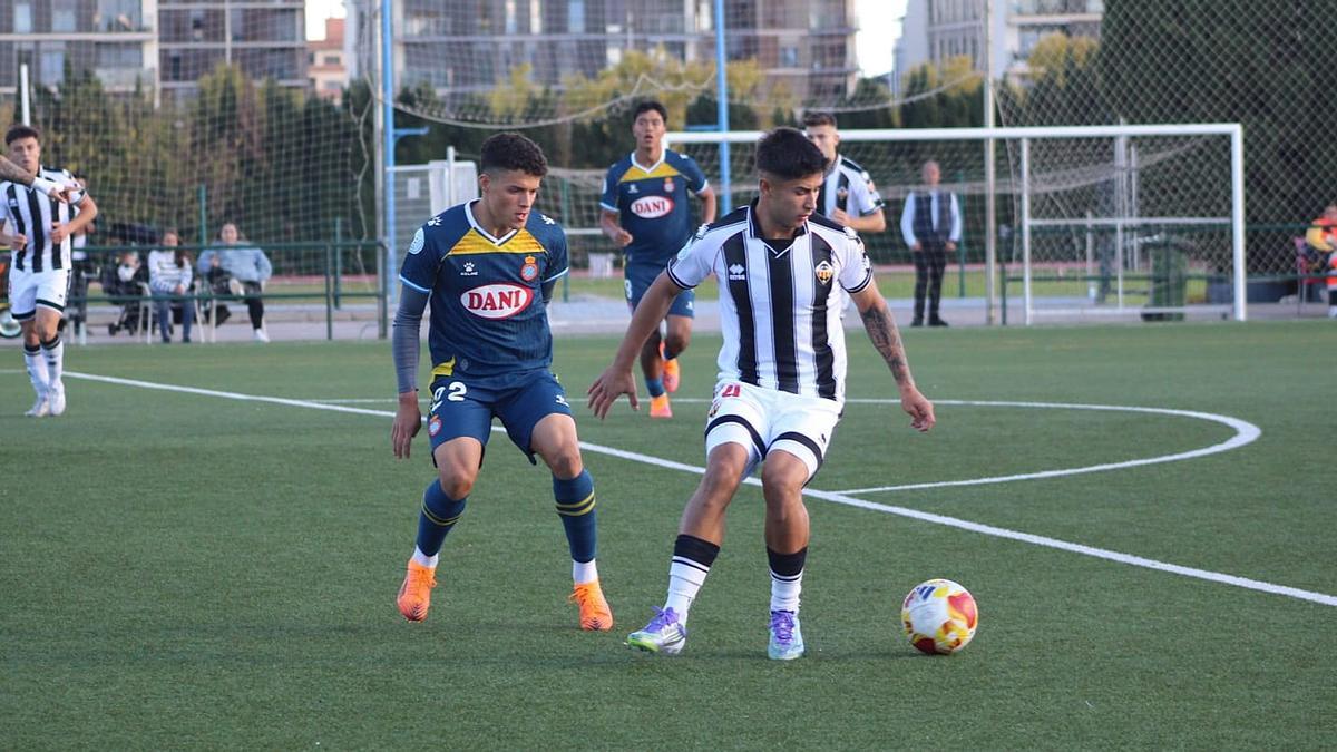 Dennis Almiñana lucha un balón en la banda vigilado por el lateral José Ángel.