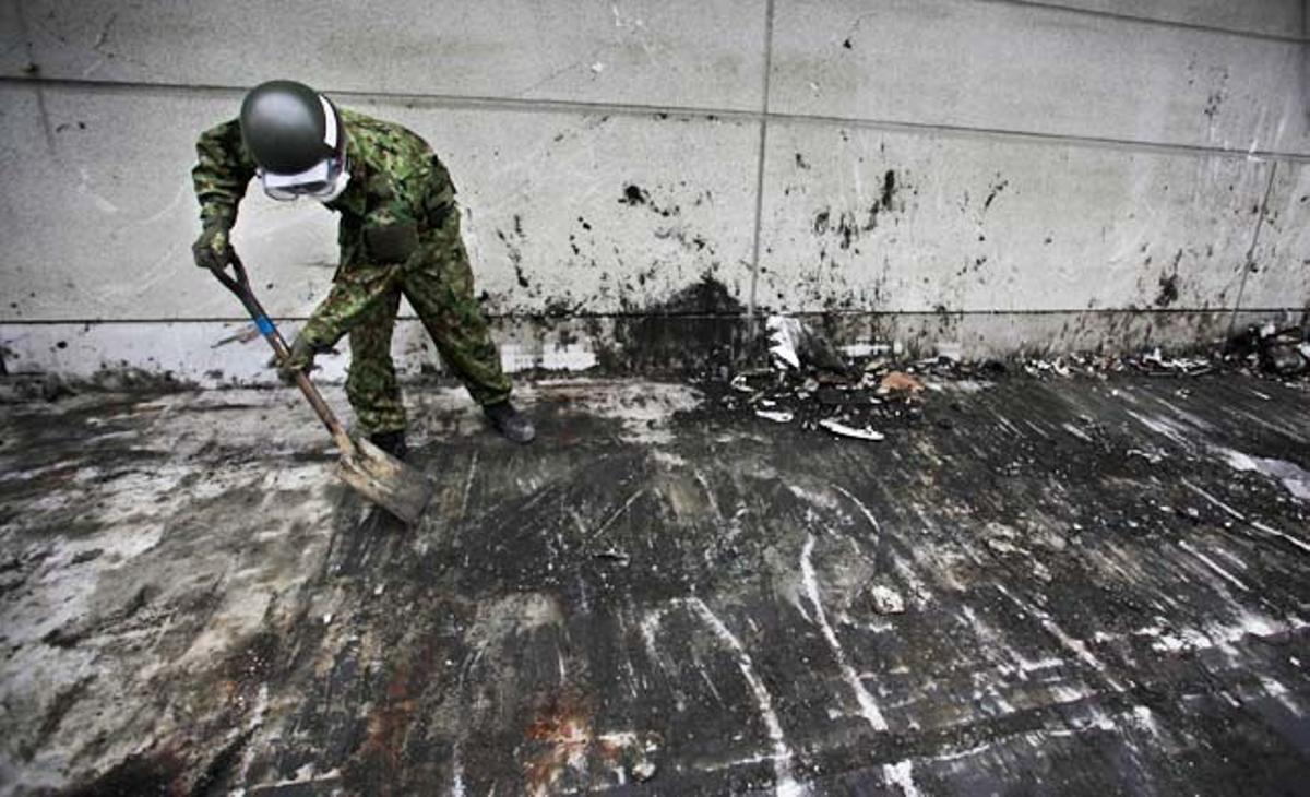Un soldat japonès a Kesennuma neteja amb una pala una àrea afectada per les destrosses del terratrèmol i el tsunami de l’11 de març.