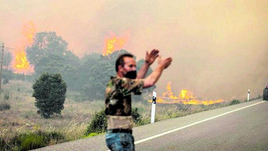 Un vecino gesticula, ayer, en una carretera. Abajo, brigadistas y civiles luchan contra el fuego. |  
// EMILIO FRAILE